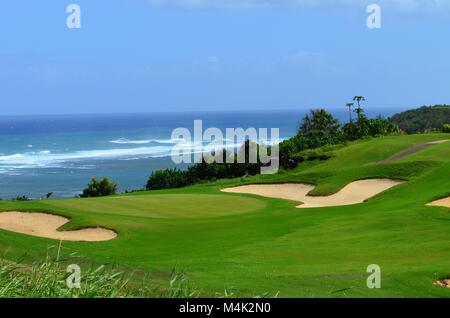 Una vista panoramica delle bianche trappole di sabbia su un campo da golf che affacciano sull'oceano onde la distanza Foto Stock