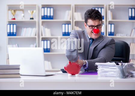 Clown imprenditore con un salvadanaio e un martello Foto Stock