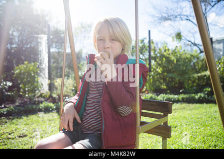 Ragazzo rilassante di swing in una giornata di sole Foto Stock