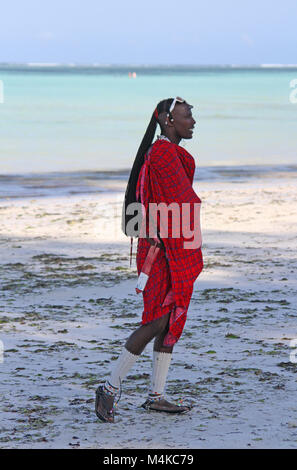 Maasai uomo a camminare sulla spiaggia, spiaggia Kiwengwa, Zanzibar, Tanzania Foto Stock