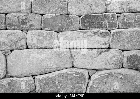 Close-up di un vecchio muro di pietra texture di sfondo nero e bianco. Foto Stock