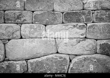 Close-up di un vecchio muro di pietra texture di sfondo bianco e nero con la vignettatura. Foto Stock