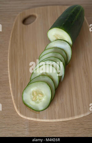 Vista aerea del cetriolo Half-Sliced su un contatore di legno pronto per il pasto Prep Foto Stock