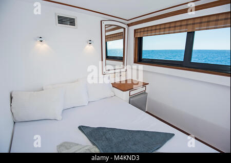 Un letto doppio nella cabina di un privato di lusso yacht a motore Foto Stock