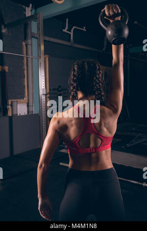 Montare donna esercizio con kettlebell in palestra Foto Stock