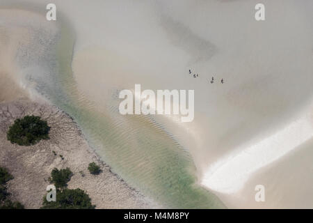 Vista aerea della lone figure a piedi attraverso le dune di sabbia con acqua Foto Stock