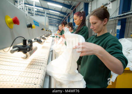 Gli operai che lavorano in lavanderia industriale Foto Stock