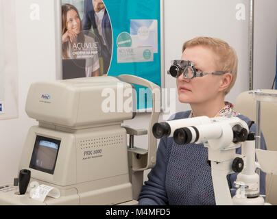 SAINT PETERSBURG, Russia - 13 febbraio 2018: Piacevole donna (con modello di rilascio) in ufficio di un oculista controlla la sua visione Foto Stock