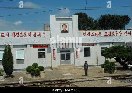 07.08.2012, Corea del Nord, Asia - una guardia femmina si trova di fronte la stazione ferroviaria nelle zone rurali del Nord Corea. Foto Stock