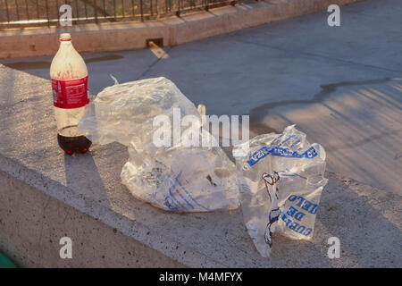 Castilla La Mancha, Toledo, Spagna; 23 Dicembre 2.017: Resti della bottiglia di Coca immondizia e sacchetti di ghiaccio in un parco Foto Stock