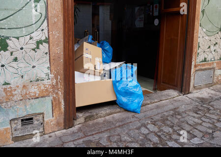 Rimane del cestino e garbage, borse di plastica e scatole di cartone nel portale di una casa in Toledo, Spagna Foto Stock