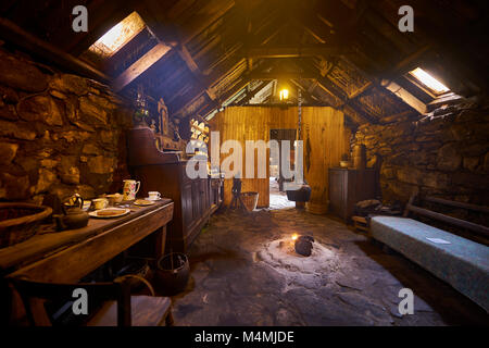 Gli interni originali della zona cucina con paet fuoco nel Blackhouse, 24 Arnol, Bragar, isola di Lewis, Scozia. Foto Stock