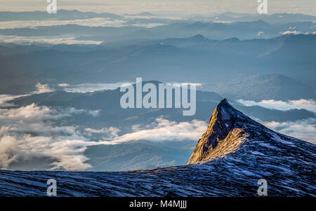 Dawn al picco del Sud uno dei picchi minori sul Monte Kinabalu a Sabah Borneo con paesaggio montuoso oltre Foto Stock