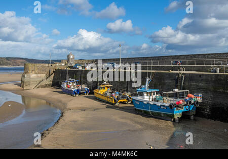 Saundersfoot Harbour e barche da pesca sul bech in South Pembrokeshire nel Galles con la marea out Foto Stock