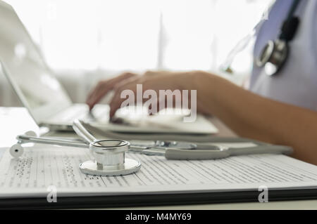 Close-up di un medico la digitazione sulla tastiera in ufficio Foto Stock