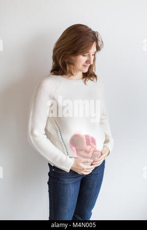 Biologia, maternità, concetto life. vi è viasual rappresentazione della posizione del bambino prima della nascita, come egli è collocato nel ventre della giovane e bella Foto Stock