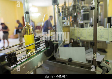 Vino bianco bottiglie etichettato in una cantina prima di pranzo e spediti in vendita. Foto Stock