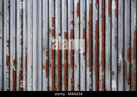 Un pezzo di metallo corrugato, arrugginito e resistente agli agenti atmosferici, tessuto per lo sfondo Foto Stock