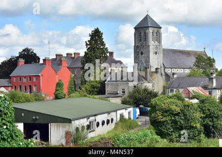 Vecchia chiesa di pietra di San Coca dietro soprattutto in edifici industriali nella piccola città irlandese di Kilcock nel 2017. Foto Stock