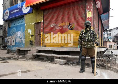 Srinagar, India. Xvii Feb, 2018. Un indiano trooper paramilitari si erge alert durante le restrizioni a Srinagar, Indiano Kashmir amministrato. Le autorità impongono delle restrizioni in parti di Srinagar come separatisti chiamato per un arresto contro 'brutale uccisione'' della Hurriyat leader Muhammad Yousuf Nadeem, spostando i detenuti politici e lifers da Srinagar prigione centrale e la permanenza di abete contro il grande esercito in Shopian uccisioni dalla Corte suprema. Credito: Saqib Majeed/SOPA/ZUMA filo/Alamy Live News Foto Stock