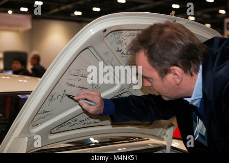 Philip Glenister firma lo sportello del bagagliaio di una Volvo P1800, esattamente lo stesso veicolo utilizzato da Roger Moor nella serie TV 'The Saint'. Phillip ha guidato questa vettura in un eppisode di Channel 4 "for the Love of Cars", che ha presentato. Foto Stock