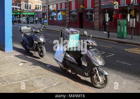 Ciclomotore Deliveroo parcheggiato su una strada di città di Nottingham, UK. Foto Stock