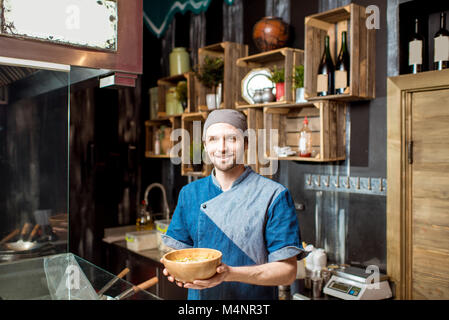 Il capo cuoco presso il ristorante asiatico cucina Foto Stock