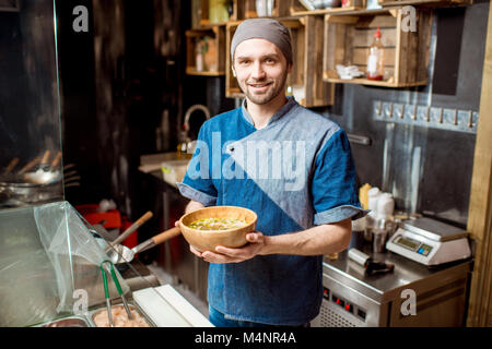Il capo cuoco presso il ristorante asiatico cucina Foto Stock