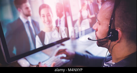 Immagine composita dell uomo al lavoro su computer con uscita cuffie Foto Stock