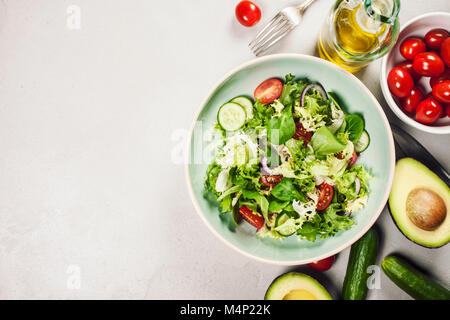 Insalata. Insalata di verdure. La molla insalata di verdure. Verdura fresca insalata di pomodori cetriolo cipolla e olio di oliva.vista superiore Foto Stock