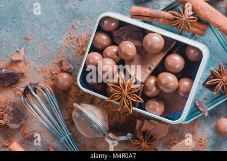 Cioccolatini rotondi in un rustico di metal box. Prodotti alimentari dolciari fotografia. Close-up con copia spazio. Foto Stock