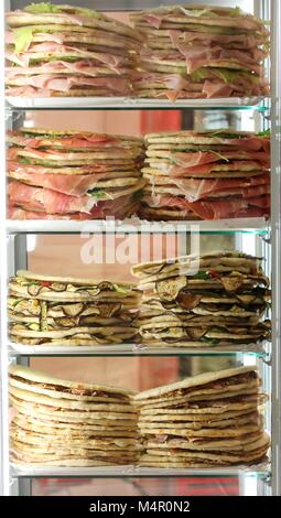 Frigorifero con un sacco di panini farciti chiamato Spianata o piadina in lingua italiana per la vendita Foto Stock