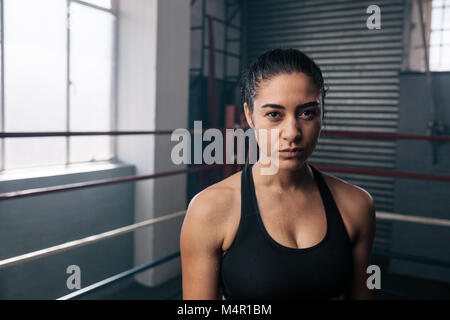 Boxer femmina all'interno di un anello di inscatolamento. Donna boxer in un boxing studio. Foto Stock