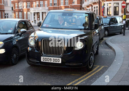 London Black Cab è andato verde come un nuovo taxi elettrico attende al di fuori di Harrods in Knightsbridge a prendere i passeggeri sul capitale nelle strade. Foto Stock