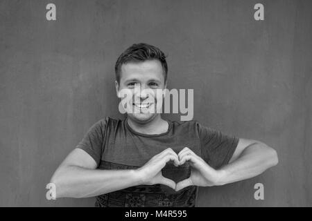 Foto in bianco e nero di uomo caucasico facendo un lato telaio del cuore Foto Stock