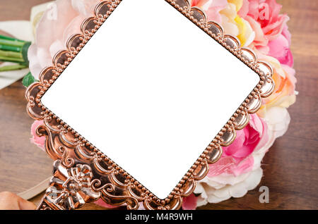 Splendido oro rosa specchio con rose su sfondo di legno. Salva percorso di clipping. Foto Stock