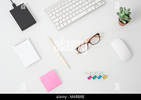 Vista dall'alto della scrivania con notebook, calcolatrice, caffettiera, penna  per occhiali e pianta in vaso Foto stock - Alamy