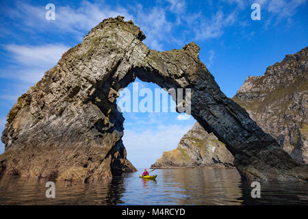 Kayak di mare sotto un arco naturale vicino Sturrall, Glencolmcille, County Donegal, Irlanda. Foto Stock