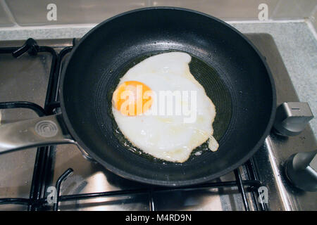 Un uovo di essere fritti in olio di oliva in una piccola rivestita in  teflon antiaderente padella su un piano cottura a gas Foto stock - Alamy