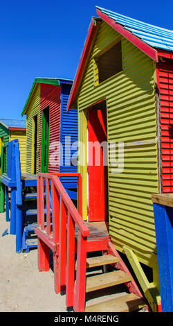 Famoso Vittoriano colorate scatole di balneazione presso San Giacomo Beach, Città del Capo, Sud Africa, presa su un soleggiato chiaro luminoso giorno sotto il cielo blu Foto Stock