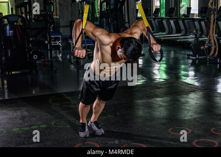 Giovani cinesi athletic uomo allenamento con TRX Foto Stock