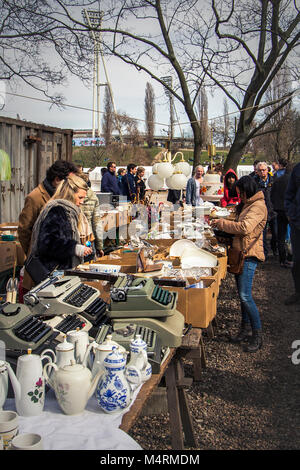 Clienti tra i cinaware e le vecchie macchine da scrivere al mercato delle pulci di Mauerpark la domenica in un primo giorno di primavera a Berlino, Germania - Europa. Foto Stock