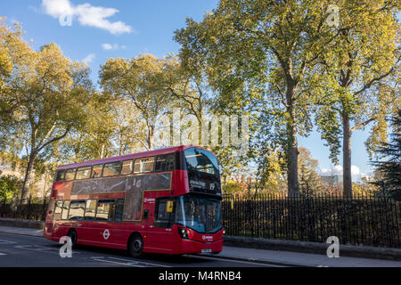 Red London bus su Theobalds Road di fronte di alberi in Grays Inn Gardens, London, Regno Unito Foto Stock