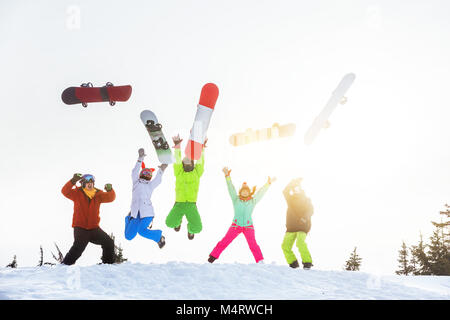 Cinque happy amici amanti dello snowboard salti e divertimento Foto Stock