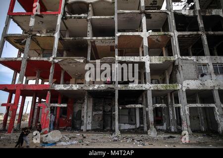 La striscia di Gaza. Xvii Feb, 2018. Bambini palestinesi giocare davanti di macerie di un edificio di Beit Lahiya town, nel nord della Striscia di Gaza, nel febbraio 17, 2018. Credito: Wissam Nassar/Xinhua/Alamy Live News Foto Stock