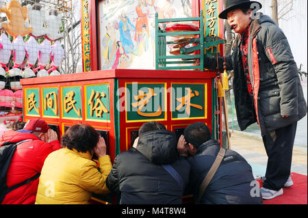 Pechino, Cina. 18 Febbraio, 2018. Un popolare artista esegue layangpian, una sorta di folk cinese forma d'arte di peep mostra accompagnato dal canto commento, durante un tempio fiera a Longtanhu Park di Pechino, capitale della Cina, Feb 18, 2018. Una varietà di fiere del tempio sono state tenute in tutto il paese durante il Festival di Primavera di vacanza. Credito: Zhang Xiuke/Xinhua/Alamy Live News Foto Stock