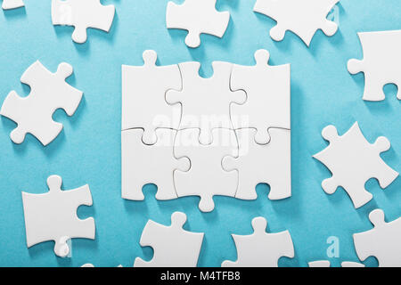 Vista in elevazione del White Jigsaw Puzzle su sfondo blu Foto Stock