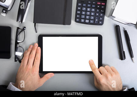 Close-up di un imprenditore tenendo premuto lo schermo è vuoto digitale compressa sulla scrivania in ufficio Foto Stock