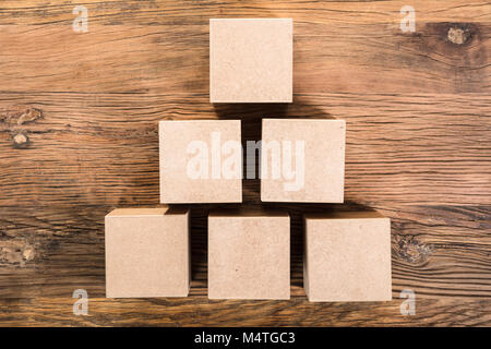 Vista in elevazione del cubo disposti in forma Piramidale sopra il tavolo in legno Foto Stock