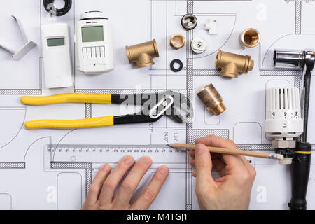 Close-up di un Architetto lavorando sul progetto di un radiatore con infissi e attrezzo di lavoro Foto Stock